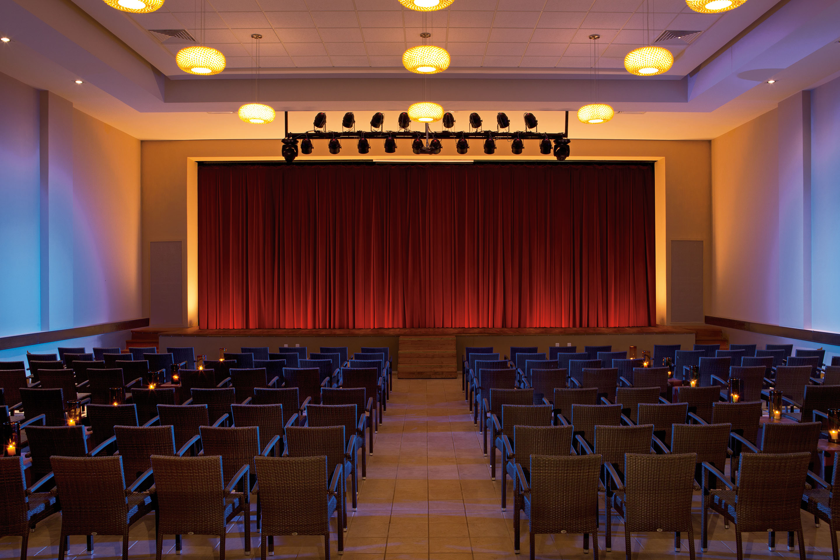 resort theater with auditorium seating and a red curtain 